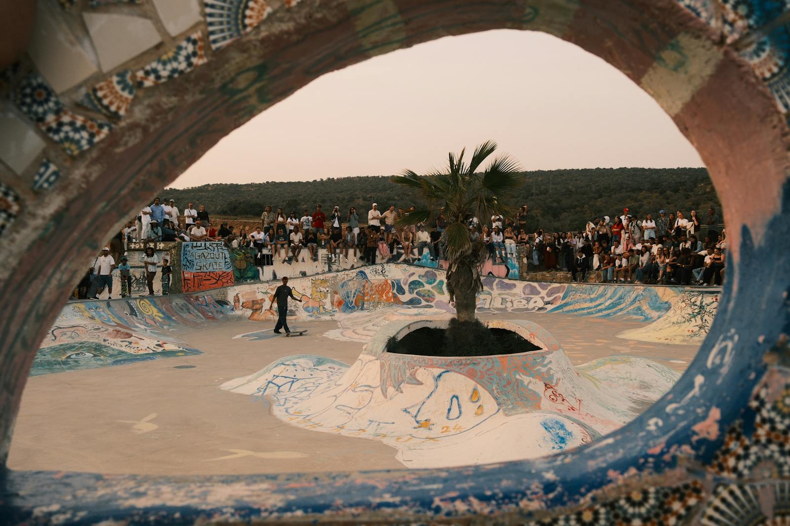 Skaters and spectators at a graffiti-art skate park